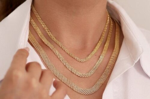 Närbild av person med flera guldfärgade Bismarckhalsband i olika längder