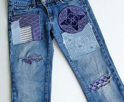 Blå jeans med dekorativa tygbitar och synliga sashikoinspirerade lagningar