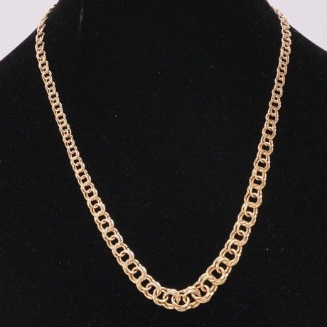 Guldfärgat Bismarckhalsband på en svart smyckesbyst